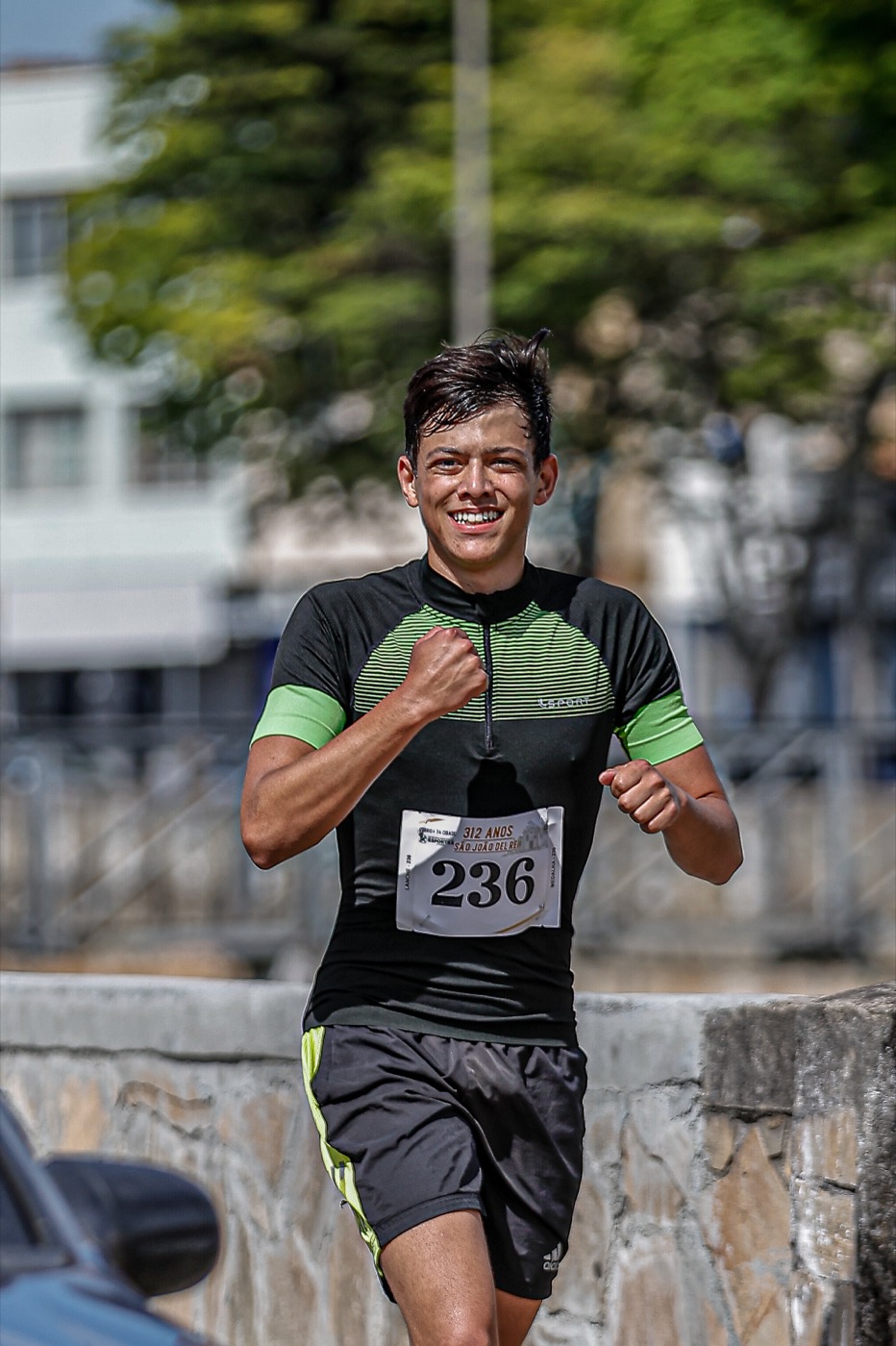 Rafael Lima correndo em prova de corrida de rua em São João del-Rei, com número 236 e sorrindo