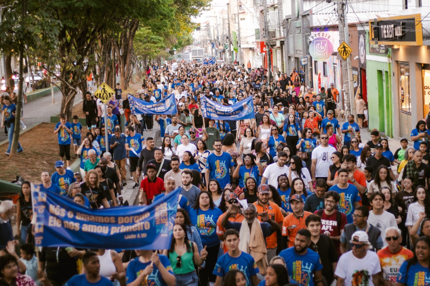 Marcha para Jesus em São João del-Rei — multidão com camisetas azuis e faixas com versículos bíblicos percorre as ruas da cidade